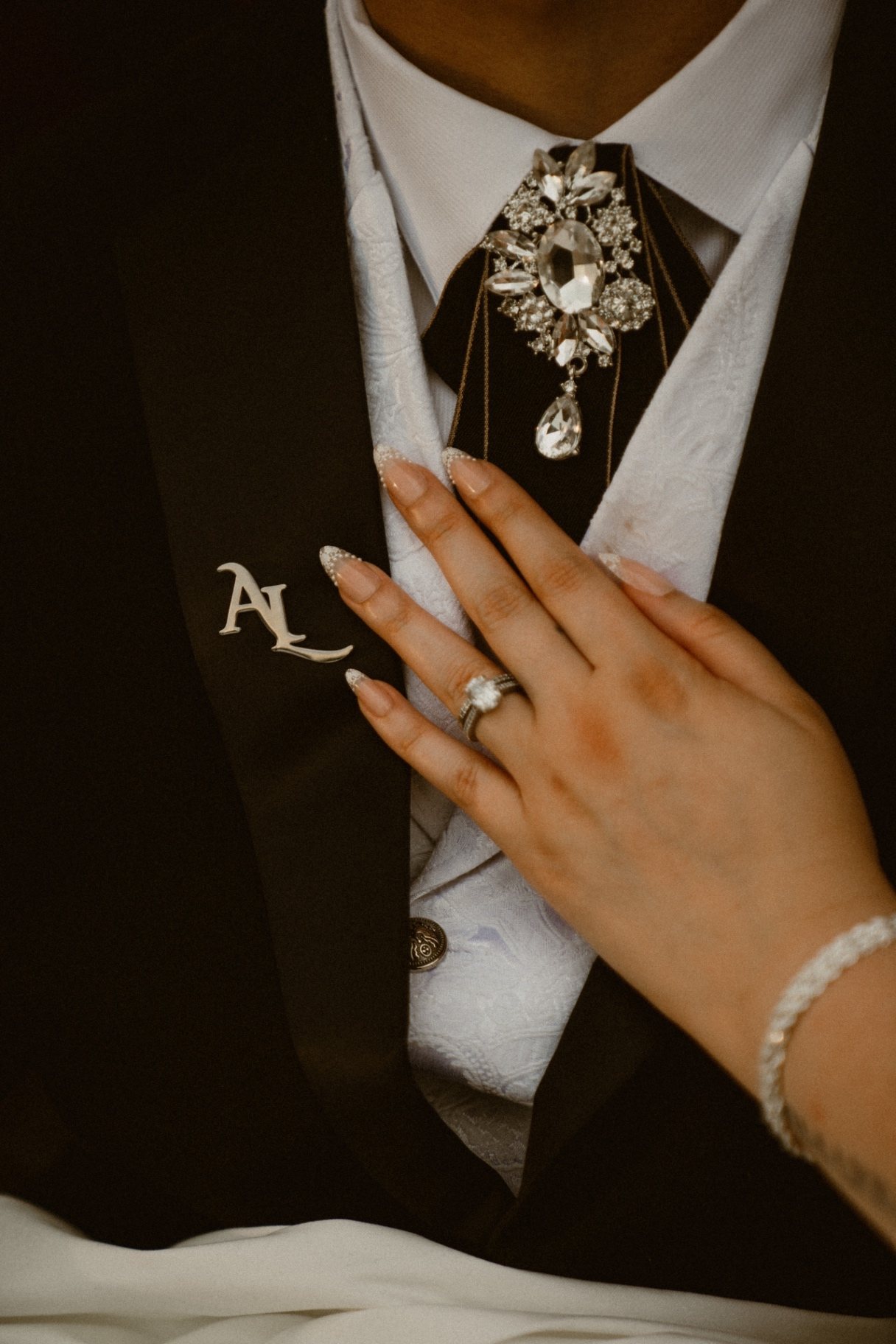 A bride's hand resting on the groom's chest