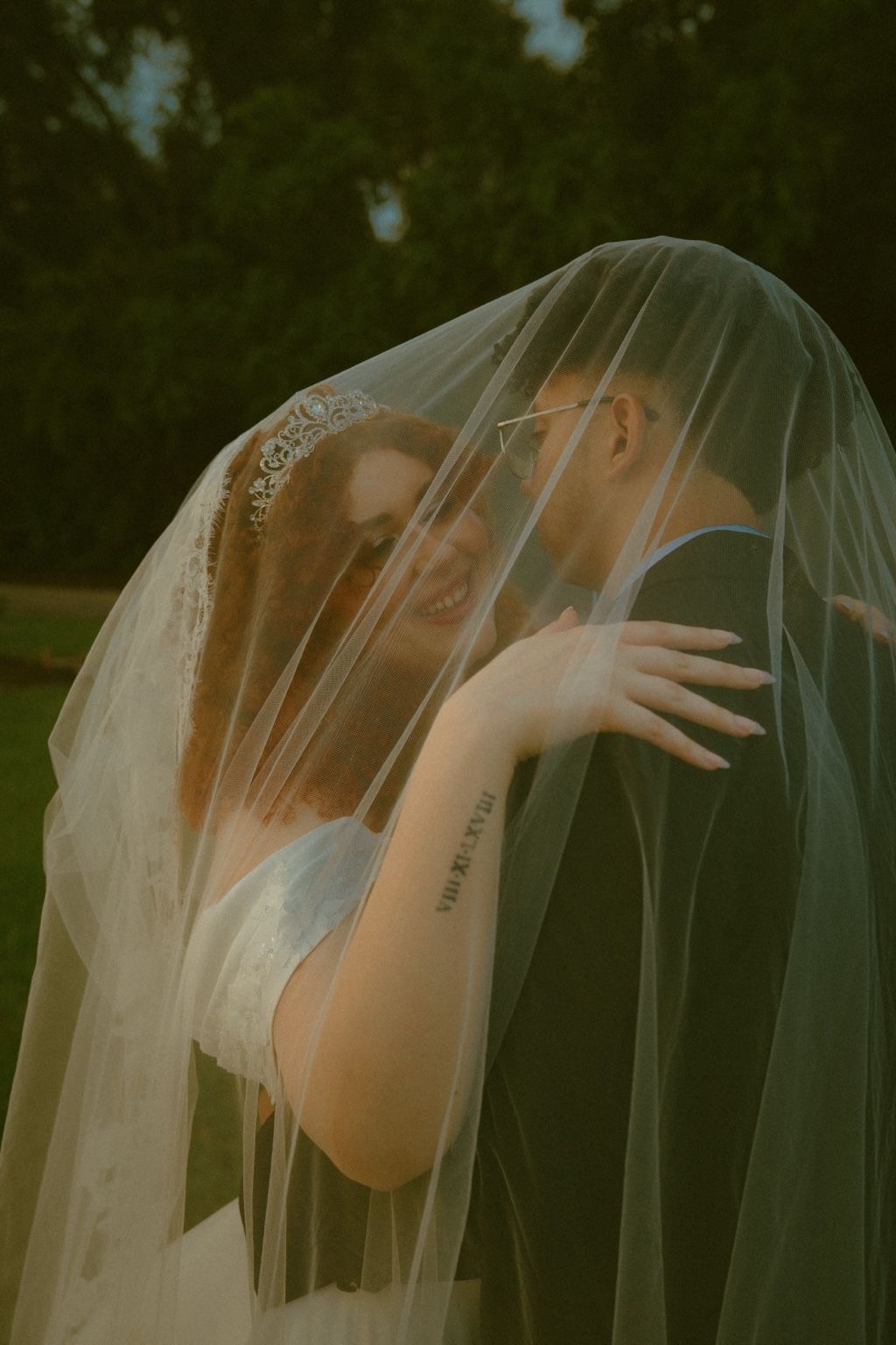A couple sharing a quiet moment beneath the bride's veil